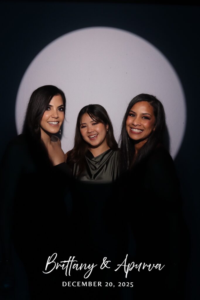 Three wedding guests posing together in the Spotlight Booth