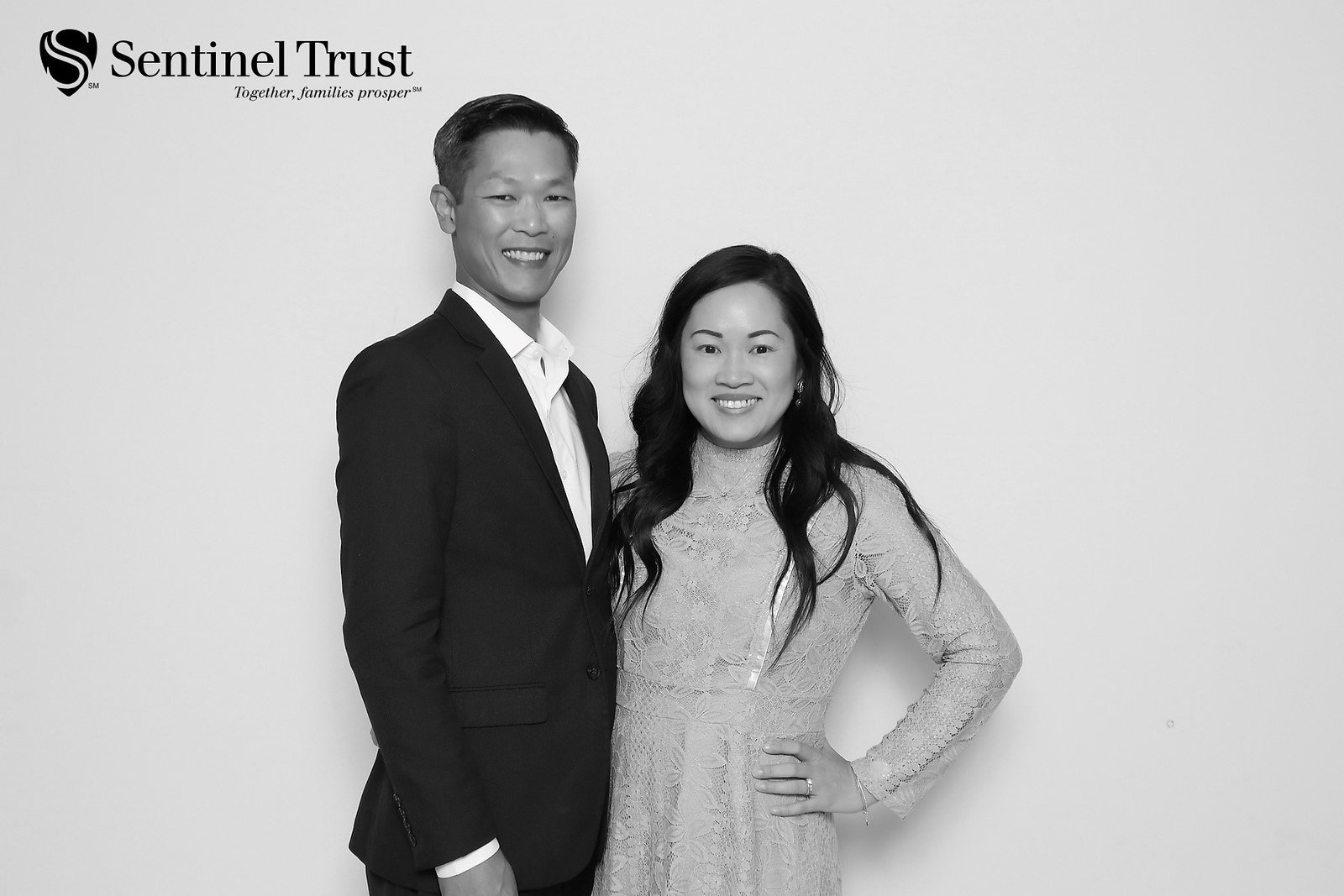 Black-and-white photo of two colleagues at a company holiday party photo booth in Houston